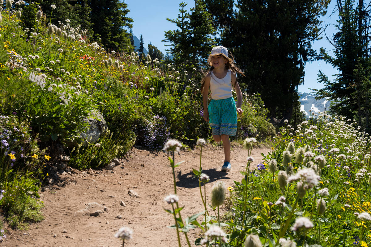 Little girl running through field of flowers